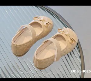 Gros plan de chaussures Mary Jane beiges pour enfants avec nœud et bride velcro