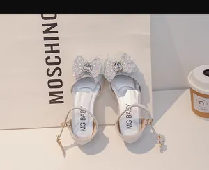 Détail de chaussure de princesse argentée pour fille avec nœud et strass en cœur