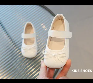 Gros plan de chaussures Mary Jane blanches pour filles avec motif matelassé et nœud élégant