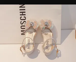 Détail d'une chaussure princesse beige pour fille avec maille et nœud en strass en cœur