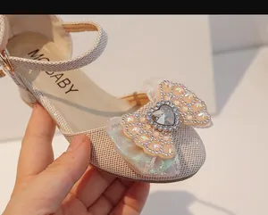 Détail de chaussures de princesse avec un cristal en cœur et un nœud orné de strass brillants