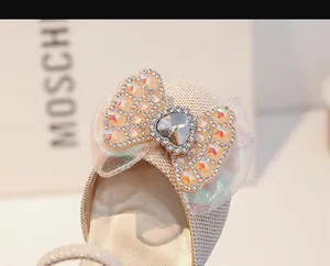 Détail d'un nœud en résille scintillante avec cristal cœur et paillettes sur chaussure fille