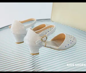 Detalle de diamantes de imitación plateados y cristales azules en zapatos de princesa niña