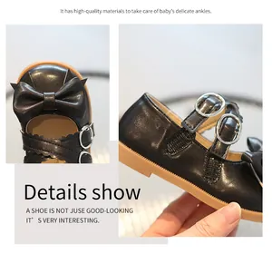 Detail of girls' black leather Mary Janes featuring cute bows and dual silver buckles