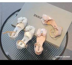Détail de chaussures princesse pour filles avec paillettes, nœud en perles et strass