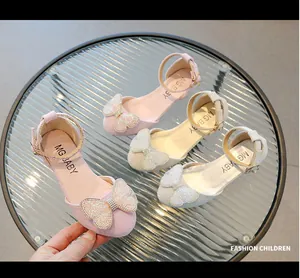 Vista dettagliata delle scarpe da principessa per bambina con strass e fiocchi rosa e argento