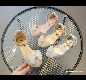 Dettaglio di scarpe da principessa con glitter rosa, beige e argento su vetro