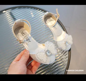 Détail de chaussures de princesse pour filles avec nœud en tulle, perles et strass brillants