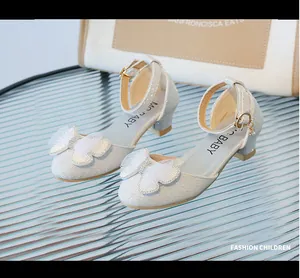 Dettaglio delle scarpe da principessa bianche glitterate per bambina con fiocco e perla