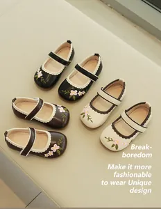 Detail of embroidered floral patterns and scalloped trim on girls Mary Jane shoes