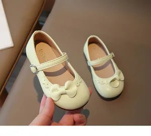 Detailansicht cremefarbener Mädchen-Mary-Janes mit Schleife und Wellenrand