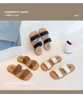 Close-up of three pairs of children's thick-soled slide sandals in black, brown, and beige