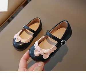 Detail von Mädchen Mary Janes Lackschuhen in Schwarz mit rosa Schleife und Borte