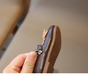 Detailansicht brauner Leder Mädchenschuhe mit zartrosa Blume und verstellbarem Riemen