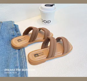 Detail view of brown puffed double-strap sandals for girls with branding on footbed
