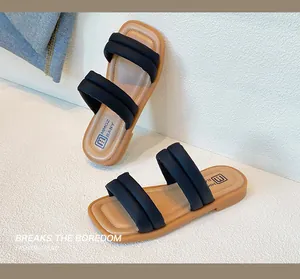 Close-up of girls' black padded straps sandals with soft brown footbed and fine stitching