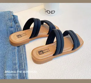 Detail of girls' black double-strap sandals with soft foam-filled fabric on white surface