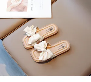 Detail view of cream girl's sandals with large bow and branded footbed padding