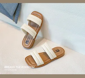 Detail of baby summer sandals featuring puffy cream straps and soft brown footbed