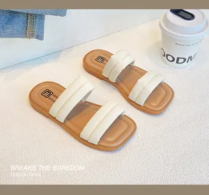Close-up of beige dual padded straps on square-toe flat slide sandals for girls