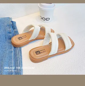 Detail view of girls' soft padded dual-strap slides with MMGZ BABY logo and tan sole
