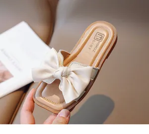 Close-up of girls apricot bow sandals with satin ribbon detail and soft square sole