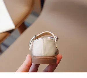 Detailansicht der cremefarbenen Kleinkind-Ballerinas mit Gummisohle und Schnalle