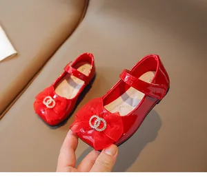 Detail von roten Lackleder-Mary-Janes für Mädchen mit Netzschleife und Strass-Schnalle