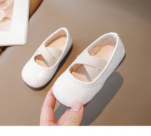 Dettaglio di scarpe Mary Jane trapuntate bianche con cinturini elastici incrociati beige