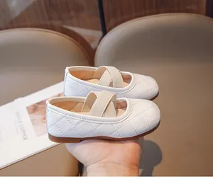 Dettaglio di ballerine Mary Jane trapuntate color crema con cinturini elastici