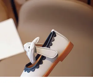 Details von Mädchen Mary Jane Schuhen mit schwarzem Wellenrand und cremefarbener Schleife