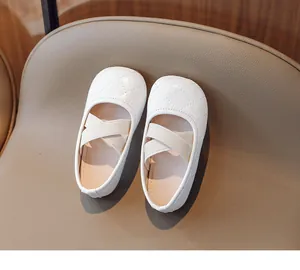 Dettaglio scarpe Mary Jane bianche da bambina con cuciture trapuntate e cinturini elastici