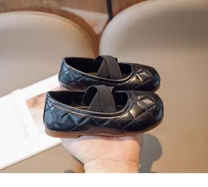 Dettaglio delle scarpe Mary Jane nere per bambini con pelle trapuntata e cinturini incrociati