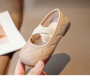 Dettaglio di ballerine beige trapuntate per bambina con cinturini incrociati e punta tonda