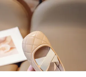 Dettaglio delle scarpe Mary Jane beige da bambina con motivo trapuntato e cinturini elastici