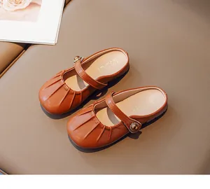 Close-up of brown Mary Jane style girls' leather mules with pleated toe detail