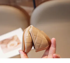 Dettaglio di scarpe da principessa beige flessibili con suola morbida pieghevole e trapuntata