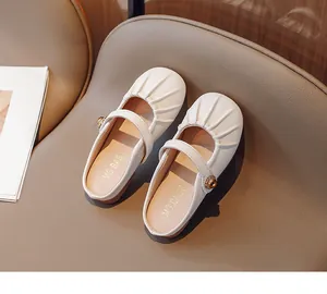 Detail of white girls' Mary Jane mule shoes with pleated toe and golden buckle