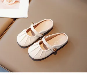 Close-up of girls Mary Jane slippers with pleated toe and golden buckle detail
