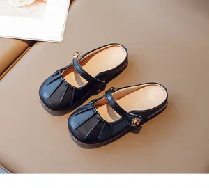 Detail of girls black Mary Jane mule shoes with pleated toe and golden buckle straps