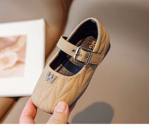 Close-up of girls' quilted leather dress shoes with bow and rhinestone buckle detail