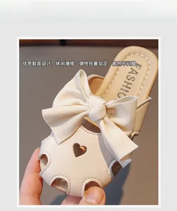 Dettaglio di sabot beige per bambina con grande fiocco e intagli a cuore