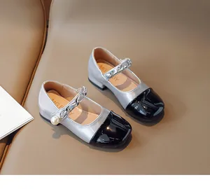 Detail of girls Mary Jane shoes featuring silver body with black toe and pearl chain
