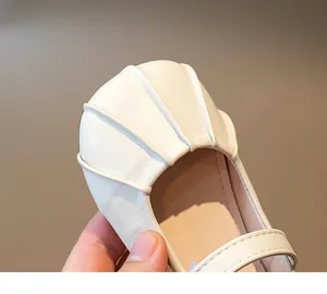 Detalle macro de zapatos Mary Jane para bebé en cuero crema con diseño de punta de concha