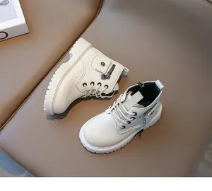 Détail de bottine enfant blanc cassé avec poche latérale, rivet étoile et semelle gomme