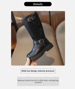 Detailed macro view of girls' black leather fashion boots with stylish double buckle straps
