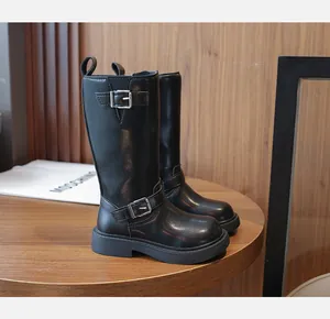 Detailed view of girls' black leather mid-calf boots with dual silver buckle straps