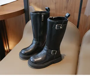 Detail view of black faux leather girls' boots featuring an inner zipper and buckle strap