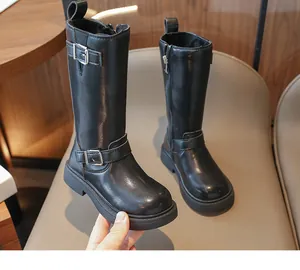 Detail of girls' black high boots with silver buckles and side zipper closure