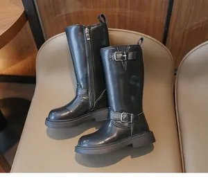 Detailed shot of girls black tall boots featuring side zipper and metal buckle straps